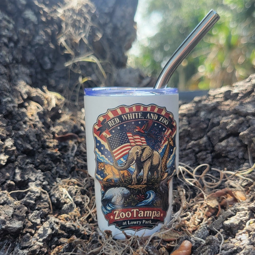 Mini tumbler shot glass with a ZooTampa Red, White, and Zoo design sitting on a tree trunk